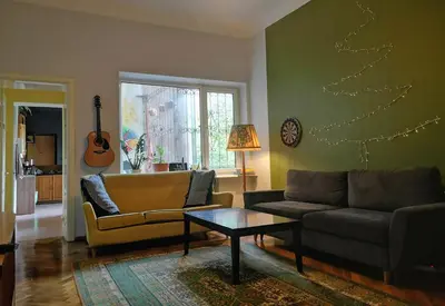 a living room with a couch and a christmas tree on the wall at The Monk's Bunk Kaunas in Kaunas