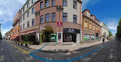 a building on a city street with a person walking past it at The Monk's Bunk Kaunas in Kaunas