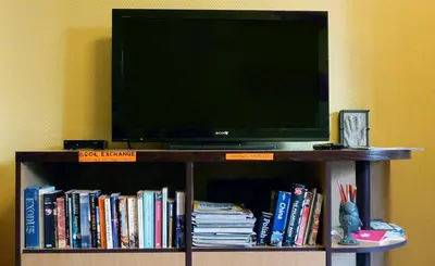 a television on a book shelf with books at The Monk's Bunk Kaunas in Kaunas