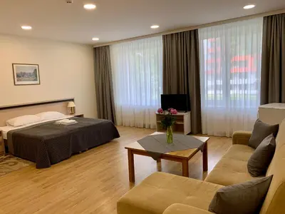 a hotel room with a bed and a couch at VESK Svečių Namai in Druskininkai