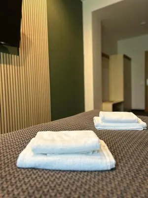two white towels sitting on top of a bed at VESK Svečių Namai in Druskininkai