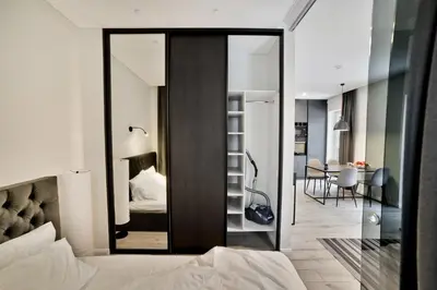 a bedroom with a mirror over a bed at City Center Loft in Kaunas