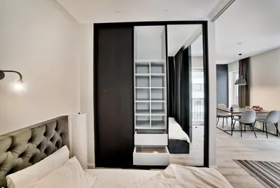 a bedroom with a bed and a dining room at City Center Loft in Kaunas