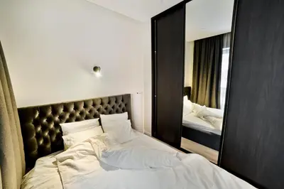 a bedroom with a large bed and a mirror at City Center Loft 2 in Kaunas