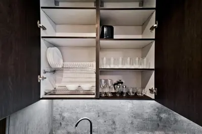 a kitchen cabinet with plates and glasses on it at City Center Loft 2 in Kaunas
