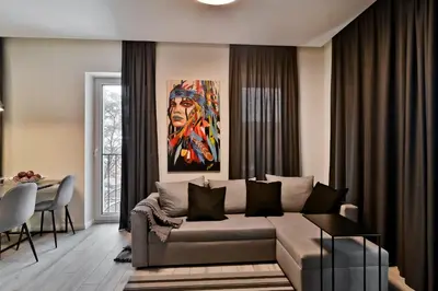 a living room with a couch and a painting at City Center Loft 2 in Kaunas