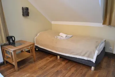a small bedroom with a bed and a table at sodyba 