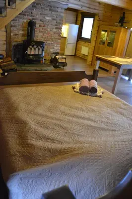 a bedroom with a bed with two slippers on it at sodyba 