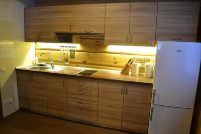a kitchen with wooden cabinets and a white refrigerator at sodyba 