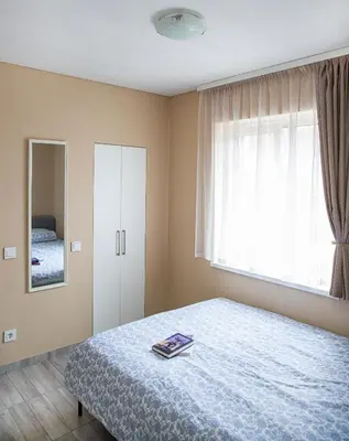 a bedroom with a bed and a window and a mirror at Chill&Go Apartment in Kaunas
