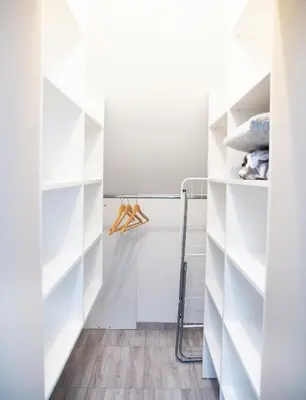 a walk in closet with white shelves at Chill&Go Apartment in Kaunas