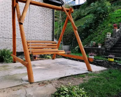 a wooden swing sitting in front of a building at Chill&Go Apartment in Kaunas