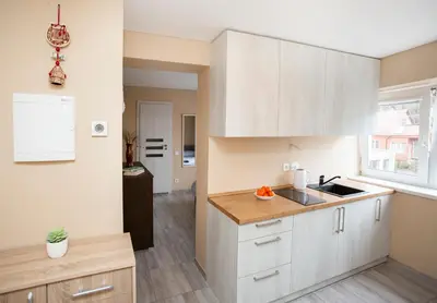 a kitchen with white cabinets and a sink at Chill&Go Apartment in Kaunas