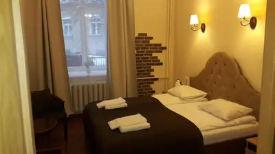a bedroom with a bed with two towels on it at Taurus Apartments Vilnius in Vilnius