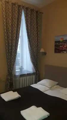 two beds in a hotel room with a window at Taurus Apartments Vilnius in Vilnius