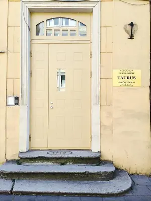 a yellow door with stairs in front of a building at Taurus Apartments Vilnius in Vilnius