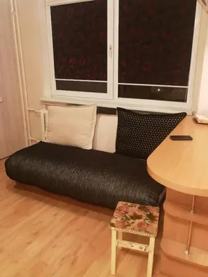 a black couch in a room with a window at Flat, 1 room, study in Panevėžys