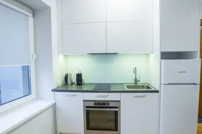 a white kitchen with a sink and a refrigerator at Bright 1BD Apartment in Old Town by Hostlovers in Kaunas