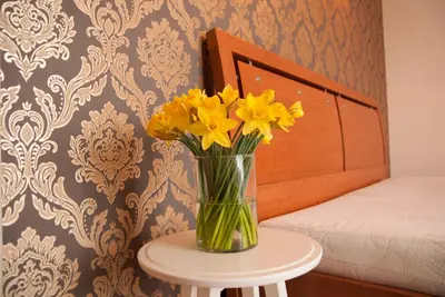 a vase of yellow flowers sitting on a table at EVArent Apartament Free parking in Vilnius