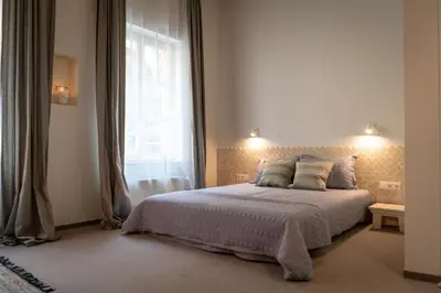 a bedroom with a large bed and a window at Mai Ram Yoga House in Vilnius
