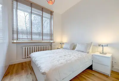 a white bedroom with a large bed and a window at Center Apartment, Vilnius, Old Town in Vilnius