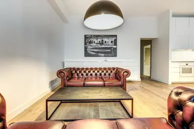 a living room with a leather couch and a table at Center Apartment, Vilnius, Old Town in Vilnius