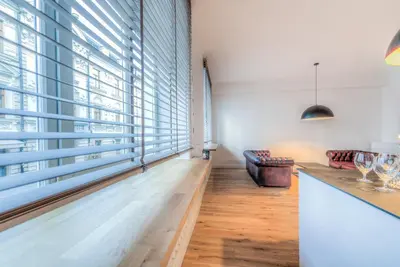 a room with large windows and a counter with wine glasses at Center Apartment, Vilnius, Old Town in Vilnius