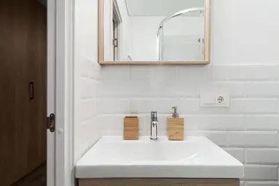 a bathroom with a white sink and a mirror at Pušyno apartamentai in Anykščiai