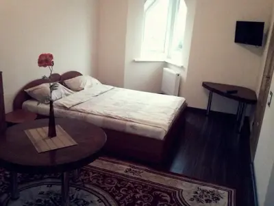 a bedroom with a bed and a table and a window at Marijonu Apartments in Panevėžys