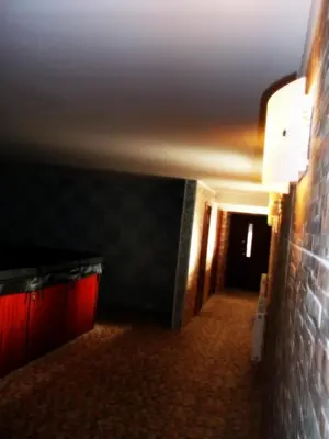 a room with a brick wall and a hallway with red lights at Marijonu Apartments in Panevėžys