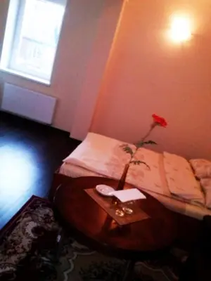 a room with a bed and a table with a rose on it at Marijonu Apartments in Panevėžys