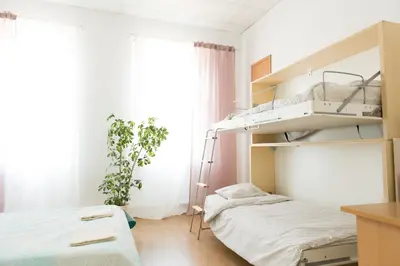 a small bedroom with a bunk bed and a window at Hostel Liberty in Kaunas