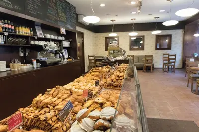 a bakery with a display case filled with different types of bread at Hostel Liberty in Kaunas