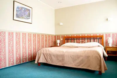 a bedroom with a bed with red and white wallpaper at Kornealita in Visaginas