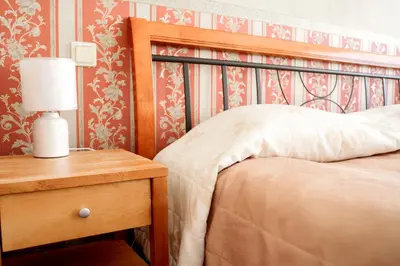 a bedroom with a bed and a table with a lamp at Kornealita in Visaginas