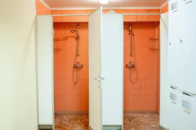 a bathroom with two shower stalls with orange walls at Kornealita in Visaginas