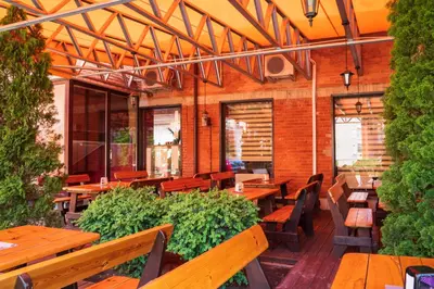 an outdoor patio with wooden tables and benches at Kornealita in Visaginas