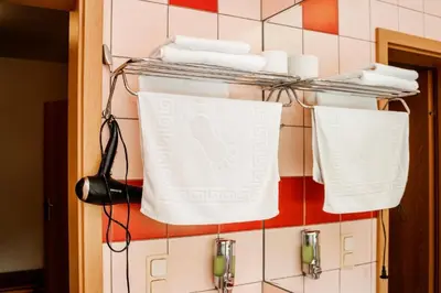 a towel rack with towels hanging on a tiled wall at Kornealita in Visaginas
