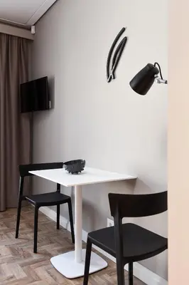 a white table with two chairs and a lamp at Somnia Apartments in Vilnius