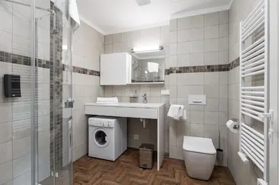 a bathroom with a washing machine and a washer at Somnia Apartments in Vilnius