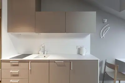 a kitchen with white cabinets and a sink at Somnia Apartments in Vilnius