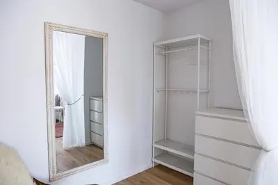 a mirror in a white room with white shelves at Spacious apartment close to the Old Town in Vilnius
