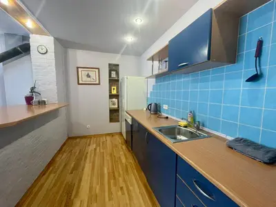 a kitchen with blue tiles on the wall and a sink at Park apartment in Kaunas