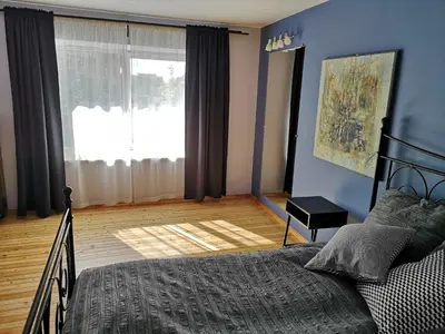 a bedroom with a bed and a large window at Park apartment in Kaunas