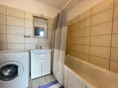 a bathroom with a washing machine and a sink at Park apartment in Kaunas