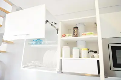 a kitchen pantry with white cabinets and shelves at Lofts - Kaunas airport in Karmėlava