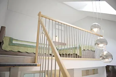 a staircase with two lights and a bed in a room at Lofts - Kaunas airport in Karmėlava