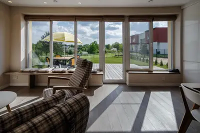 a living room with two chairs and a large window at Geras miegas in Druskininkai