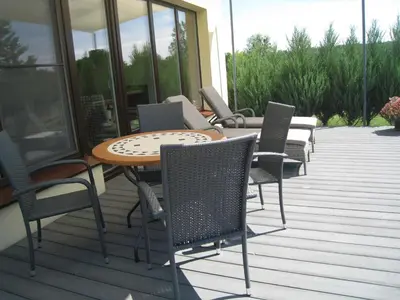 a group of chairs and a table on a deck at Geras miegas in Druskininkai