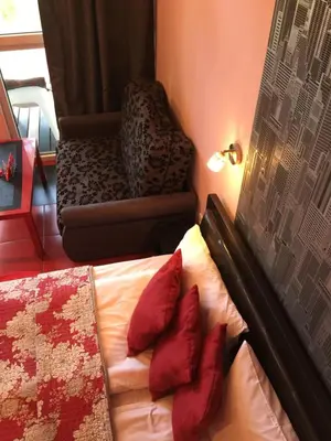 a bedroom with a bed with red pillows and a chair at VIP Red Love house for 2 in Shilagalyay